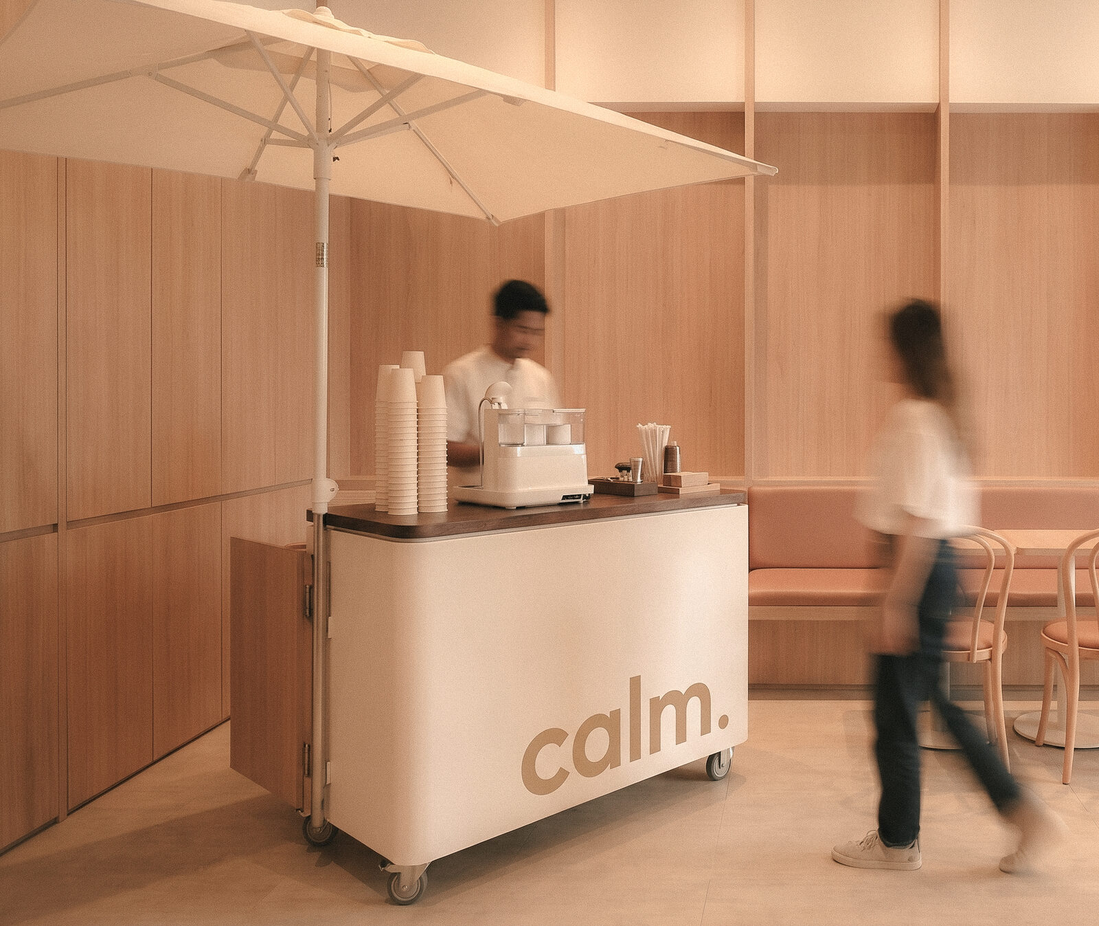 A Calm.-branded mobile coffee cart with barista serving in a modern lounge