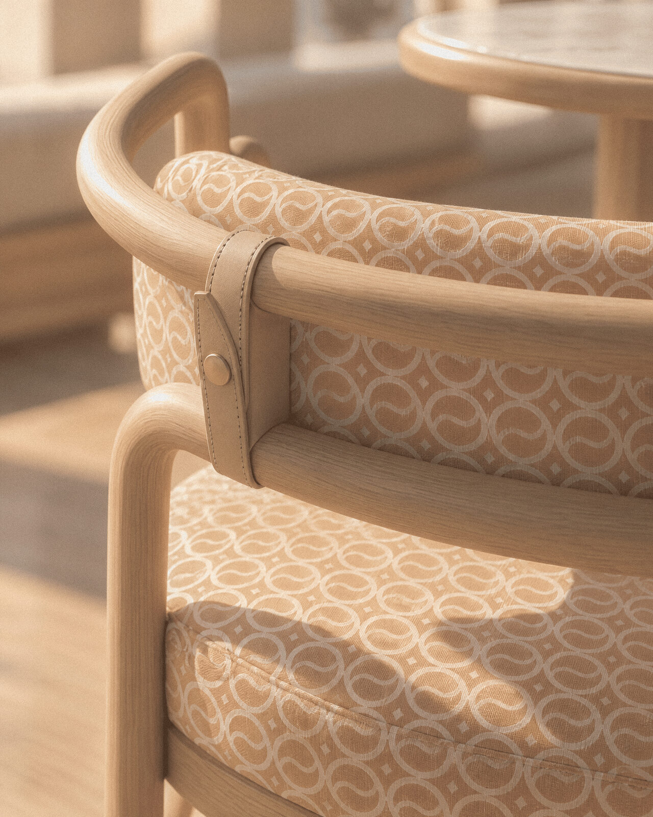 Close-up of a curved timber chair with patterned fabric and leather detail